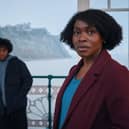 Rakie Ayoala as Christine, stood on a pier with Jordan Wilks as Connor in the background behind her (Credit: BBC/Little Door Productions/Simon Ridgway)