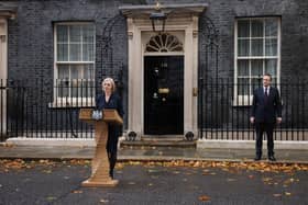 Liz Truss speaks in Downing Street, watched by husband Hugh O’Leary, as she resigns as UK Prime Minister (Getty Images)