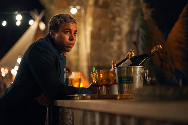 Aaron Anthony as Jamie in The Pact S2, sat at the bar with drinks in front of him (Credit: BBC/Little Door Productions/Simon Ridgway)
