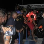 Indonesian search and rescue team personnel carry a victim after a boat caught fire