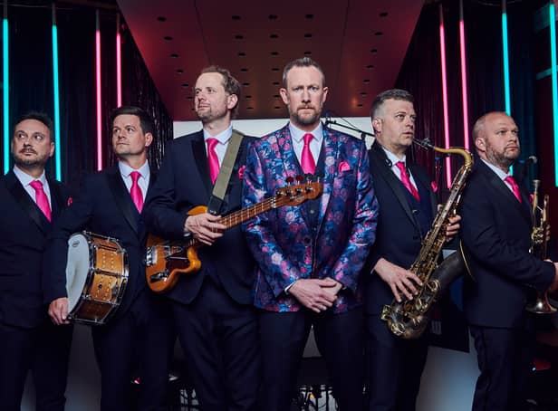 <p>Alex Horne (band leader, centre, wearing a floral jacket) and the Horne Section, comprised of Joe Auckland (trumpet and banjo), Mark Brown (saxophone and guitar), Will Collier (bass), Ben Reynolds (drums and percussion), Ed Sheldrake (keyboards). (Credit: Channel 4)</p>