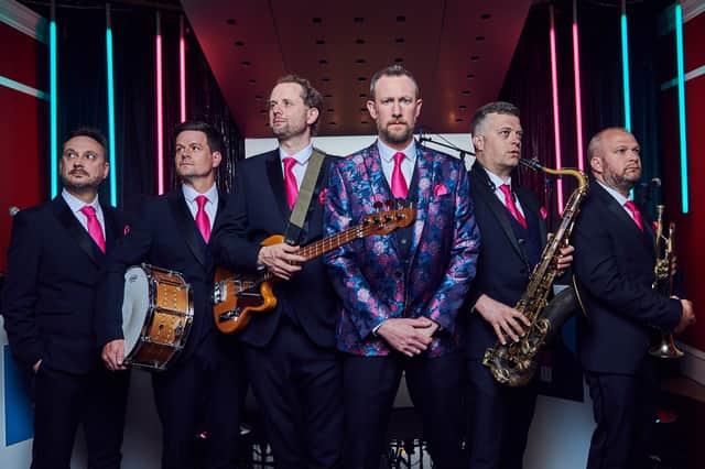 Alex Horne (band leader, centre, wearing a floral jacket) and the Horne Section, comprised of Joe Auckland (trumpet and banjo), Mark Brown (saxophone and guitar), Will Collier (bass), Ben Reynolds (drums and percussion), Ed Sheldrake (keyboards). (Credit: Channel 4)