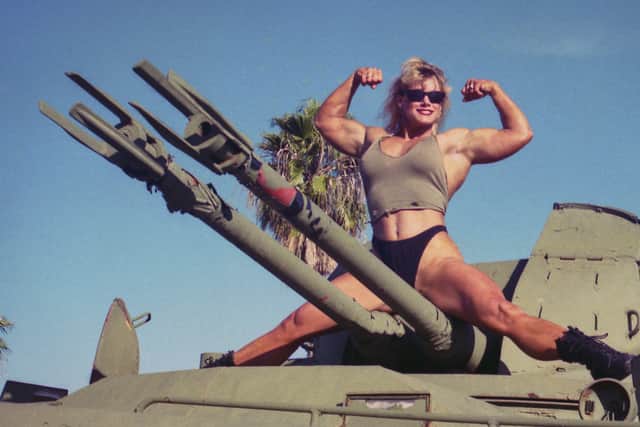 Bodybuilder Sally McNeil, posing atop a tank (Credit: Netflix)