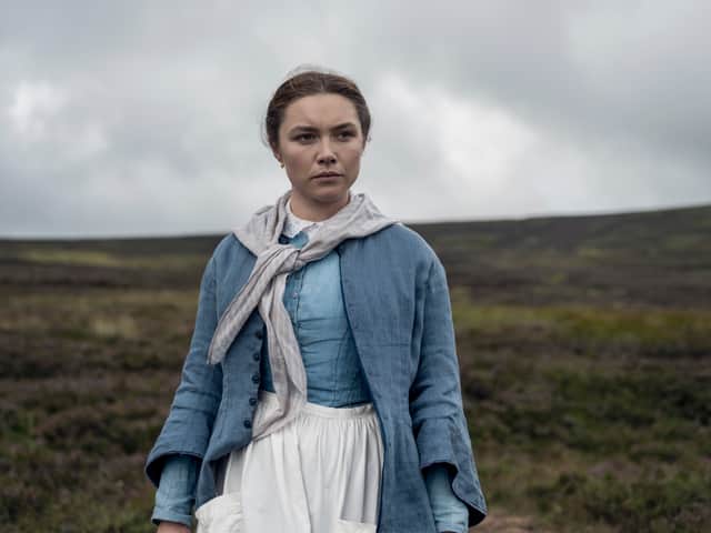Florence Pugh as Lib Wright in The Wonder, wearing blue on a windswept moor (Credit: Aidan Monaghan/Netflix)