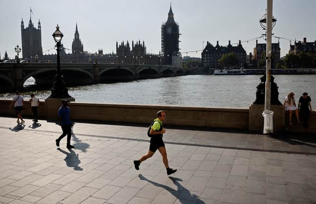 A jogger runs along the south bank of the River Thames, opposite the Houses of Parliament