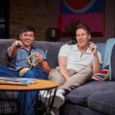 Tom Daley and Dustin Lance Black on Celebrity Gogglebox. Daley is knitting with one hand and holding the remote in the other (Credit: Channel 4)