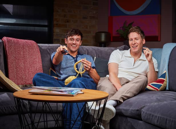 Tom Daley and Dustin Lance Black on Celebrity Gogglebox. Daley is knitting with one hand and holding the remote in the other (Credit: Channel 4)