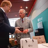 King Charles  is presented the new commemorative £5 coin, celebrating the Duke of Edinburgh's lifetime in the public service, that the Prince struck himself, by Royal Mint CEO Adam Lawrence during a tour of The Royal Mint's visitor centre on July 11, 2017