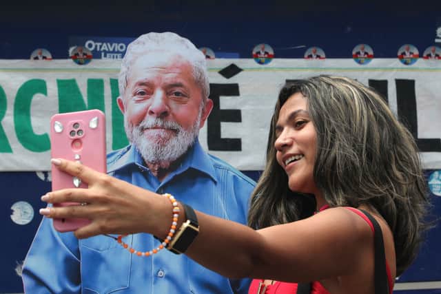 A voter takes a picture with a cardboard cutout of Lula. Credit: Joao Laet/Getty Images