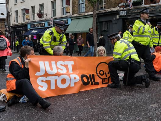 Police officers speak to Just Stop Oil supporters (Wiktor Szymanowicz/Anadolu Agency via Getty Images)