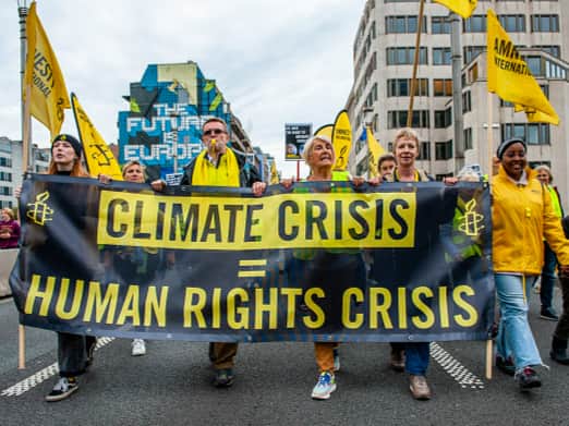 People are holding a banner from Amnesty International, during a massive climate demonstration organized in Brussels (Romy Arroyo Fernandez/NurPhoto via Getty Images)