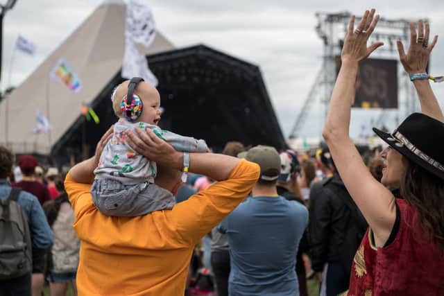 A family with a baby wearing ear defenders on his fathers shoulders watch Hacienda Classical on the Pyramid stage at Glastonbury Festival 2017 (Photo: Chris J Ratcliffe/Getty Images)