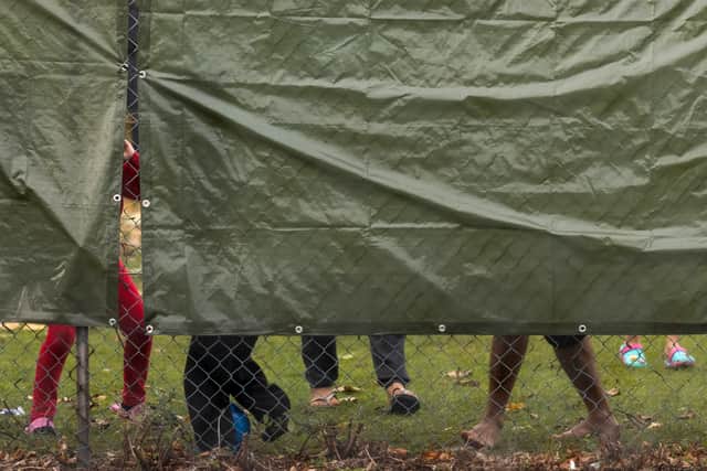 Families play behind tarpaulin inside a migrant holding facility at Manston Airfield on November 02, 2022 in Ramsgate, England. Several thousand migrants are currently staying at this former Royal Air Force base, with hundreds moved here several days ago after a petrol-bomb attack on a processing centre in Dover. (Photo by Dan Kitwood/Getty Images)