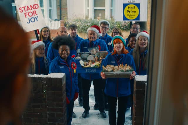 A group of Tesco employees who look like the exact midpoint between carol singers and political canvassers (Credit: Tesco)