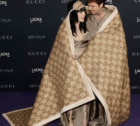 Billie Eilish and Jesse Rutherford in matching Gucci pyjamas and Gucci blanket. (Photo by Kevin Winter/Getty Images)