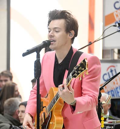 Harry Styles performing in an eye-catching pink suit.  (Photo by Mike Coppola/Getty Images)