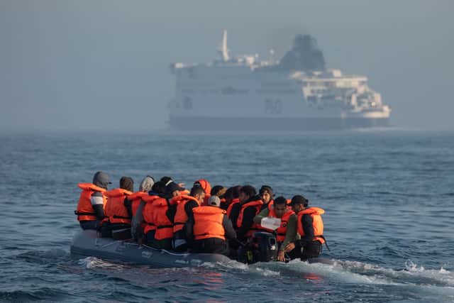 An inflatable craft carrying migrant men, women and children crosses the shipping lane in the Channel off the coast of Dover, England. Credit: Getty Images