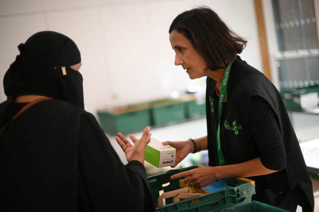 A volunteer, right, speaking with a member of the public inside a foodbank in Hackney, north-east London in October.  (Photo: Daniel Leal/AFP via Getty Images)