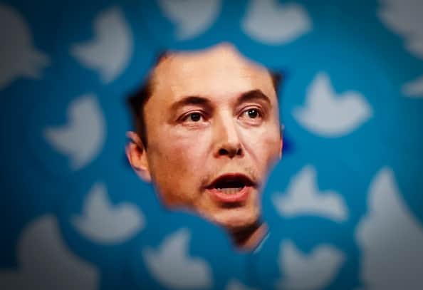 An image of new Twitter owner Elon Musk is seen surrounded by Twitter logos (Photo by STR/NurPhoto via Getty Images)