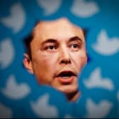 An image of new Twitter owner Elon Musk is seen surrounded by Twitter logos (Photo by STR/NurPhoto via Getty Images