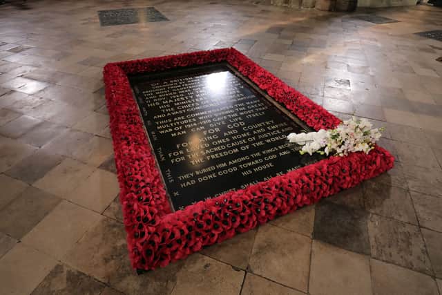 A bouquet of flowers lies on the grave of the Unknown Warrior following a service to mark the centenary of the burial of the Unknown Warrior ahead of Remembrance Sunday at Westminster Abbey in London on November 4, 2020. - In the small private ceremony, The Queen honoured the Unknown Warrior and the Royal Familys own associations with the First World War and the grave at Westminster Abbey. As part of the ceremony, a bouquet of flowers featuring orchids and myrtle - based on Her Majestys own wedding bouquet from 1947 - was placed on the grave of the Unknown Warrior in an act of remembrance. The gesture reflected the custom of Royal bridal bouquets being placed on the grave. (Photo by Aaron Chown / POOL / AFP) (Photo by AARON CHOWN/POOL/AFP via Getty Images)
