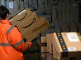 An employee places packed goods tons container at the distribution centre of US online retail giant Amazon in Moenchengladbach, on December 17, 2019. (Photo by INA FASSBENDER/AFP via Getty Images)