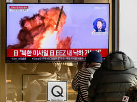 People sit near a television showing a news broadcast with file footage of a North Korean missile test, at a railway station in Seoul, South Korea.  Credit: ANTHONY WALLACE/AFP via Getty Images