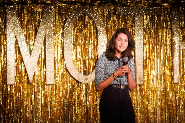 Lara Ricote in Live at the Moth Club, performing standup in front of a glittery gold curtain (Credit: UKTV / Claire Haigh)