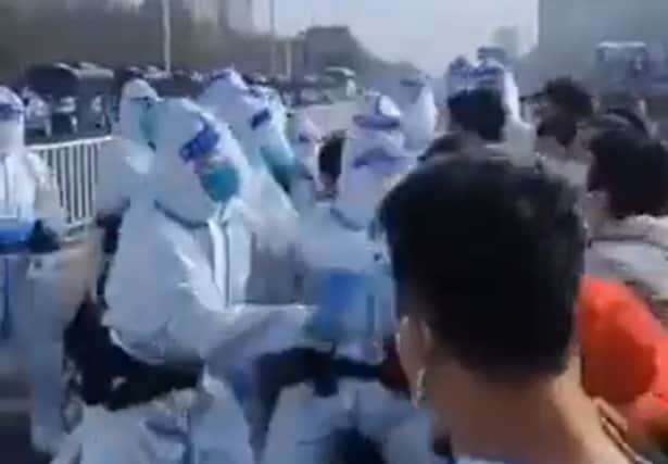 People seen in hazmat suits allegedly assaulting workers at Foxconn Zhengzhou iPhone plant in this screen grab obtained from a video released 23 November, 2022.  (Twitter user @guhj797)
