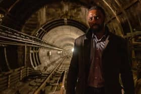 Idris Elba as Luther in the upcoming Luther movie, walking through a dark and disused underground tunnel (Credit: Netflix)