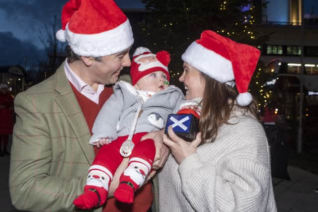 Little Hector Tully, aged one, has turned on the Christmas lights at the Royal Hospital for Children and Young People, Edinburgh, where he was cared for after being born premature. He is pictured with his parents Marie Clare and Angus Tully. 