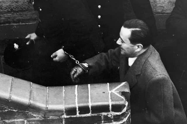 John Haigh (1909 - 1949), the 'Acid Bath Murderer' arrives, handcuffed to a police detective, at Horsham town hall courtroom for his trial. 