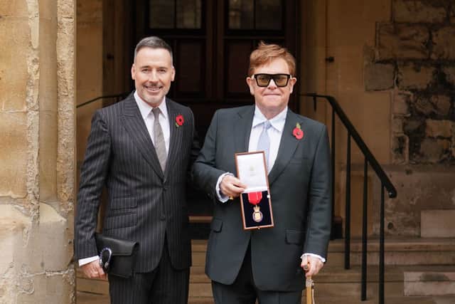 Sir Elton John, with his partner David Furnish, after being made a member of the Order of the Companions of Honour for services to Music and to Charity during an investiture ceremony at Windsor Castle on November 10, 2021 in Windsor, England. (Photo by Dominic Lipinski - WPA Pool/Getty Images)