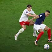 Kylian Mbappe is tackled by Poland’s Matty Cash