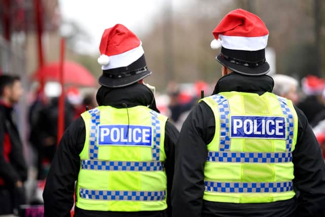Police officers are seen wearing Christmas hats (Photo by Dan Mullan/Getty Images)