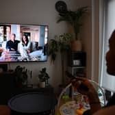 A woman poses as she watches an episode of the newly released Netflix docuseries “Harry and Meghan” (AFP via Getty Images)