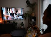 A woman poses as she watches an episode of the newly released Netflix docuseries “Harry and Meghan” (AFP via Getty Images)