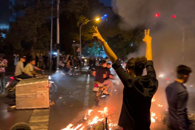 A picture obtained by AFP Iran shows shows a demonstrator raising his arms and makes the victory sign during a protest for Mahsa Amini. Credit: Getty Images