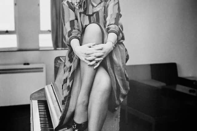 British actress and singer Ruth Madoc sitting on a piano, UK, 25th November 1983. (Photo by Harry Dempster/Daily Express/Hulton Archive/Getty Images)