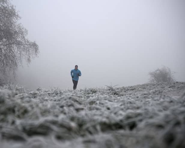 A runner makes their way through fog on a frosty morning at Primrose Hill in north London on11  December (Photo: JUSTIN TALLIS/AFP via Getty Images)