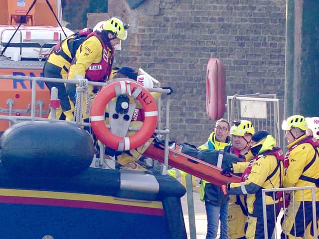 Members of the RNLI remove a stretcher and body bag from the Dover lifeboat after it returned to the Port of Dover following a large search and rescue operation launched in the Channel. Credit: PA
