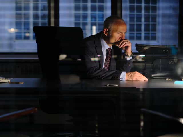 Mark Bonnar as DS Clive Timmons, working a late night shift alone, illuminated only by the glare of his desktop (Credit: ITVX)