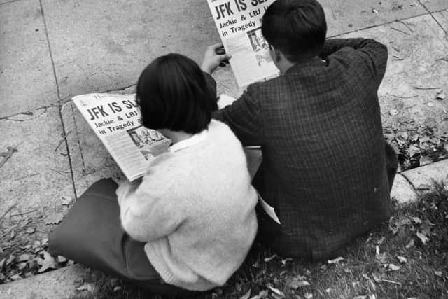 Two people in Lafayette Park, Washington, reading the newspaper reports of President John F Kennedy’s assassination (Photo: Getty Images)