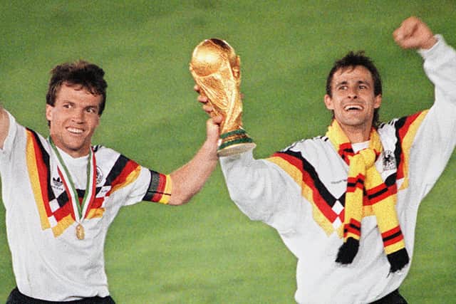 West German midfielder Lothar Matthaeus and forward Pierre Littbarski celebrate with the World Cup trophy after their team beat the defending champions Argentina 1-0 . (Getty Images)