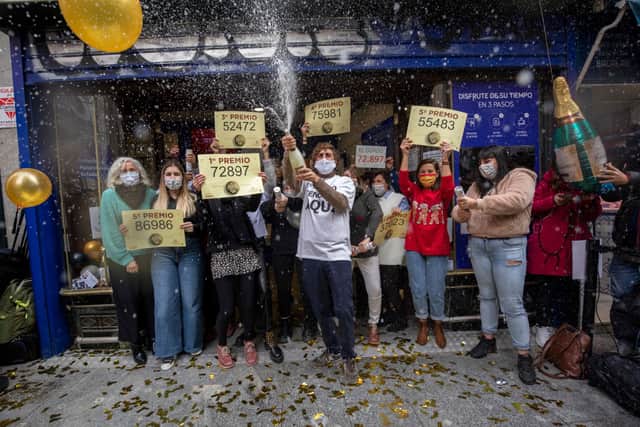 ‘Doña Manolita’ lottery shop owners and employees celebrate after selling the winning ticket number of Spain’s Christmas lottery  (Photo by Pablo Blazquez Dominguez/Getty Images)
