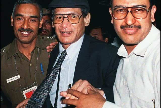 Notorious criminal Charles Sobhraj (C) is escorted by police upon his arrival at Indira Gandhi International Airport on April 7, 1997 near New Delhi, from where he will be deported to France (Photo by TEKEE TANWAR/AFP via Getty Images)