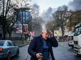 An injured man stands on a street after Russian shelling to Ukrainian city of Kherson on December 24. Credit: DIMITAR DILKOFF/AFP via Getty Images