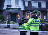 Police officers on duty at the Lighthouse Inn in Wallasey Village, near Liverpool, after a woman died and multiple people were injured in a shooting incident on Christmas Eve. Credit: PA