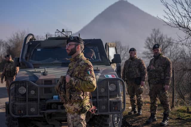 Italian soldiers serving in a NATO-led international peacekeeping mission in Kosovo patrol near a road barricaded with trucks by Serbs in the village of Rudare (AFP via Getty Images)