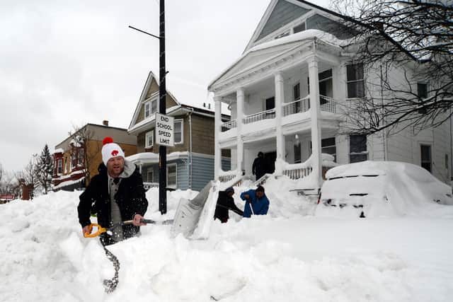 Luke Bennett helps to clear heavy snow for his neighbours in Buffalo, New York on 27 December 2022 (Photo: John Normile/Getty Images)